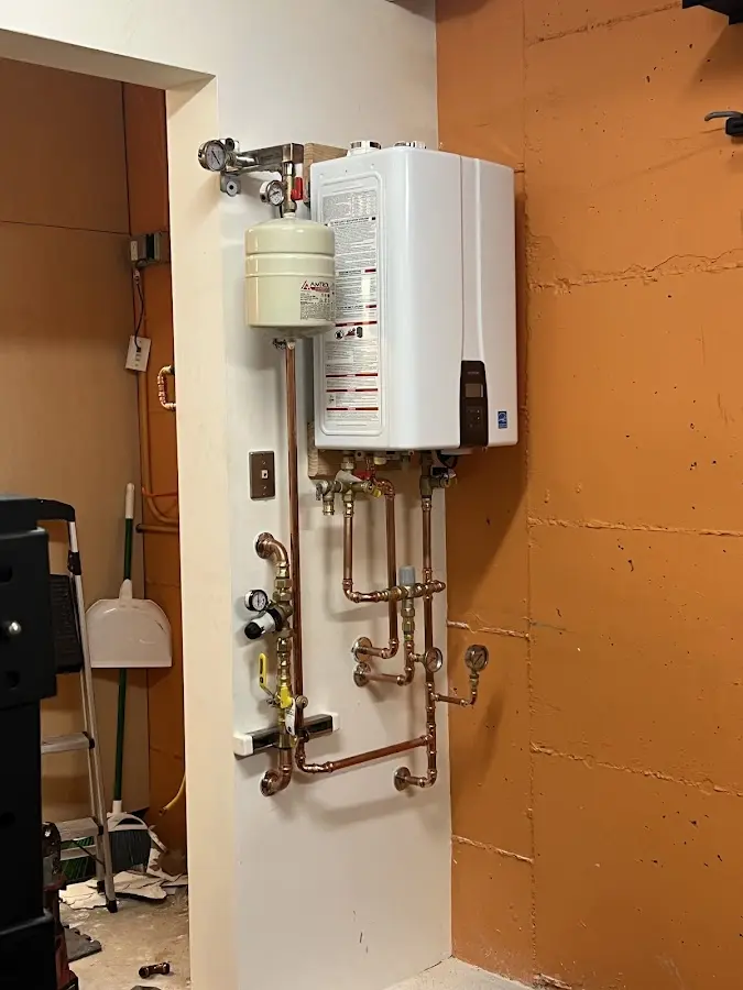 Plumbing technician inspecting water heater connections in Mishawaka